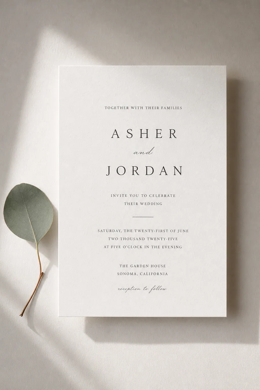 Modern minimalist wedding invitation with clean typography on off-white paper.